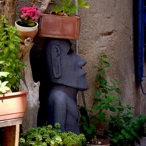 Une statue de l'Ile de Pâques au milieu de pots de plantes dans une ruelle - France  - collection de photos clin d'oeil, catégorie clindoeil